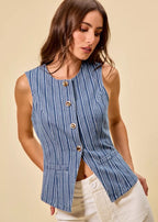 Woman wearing a blue striped sleeveless top with buttons on a beige background