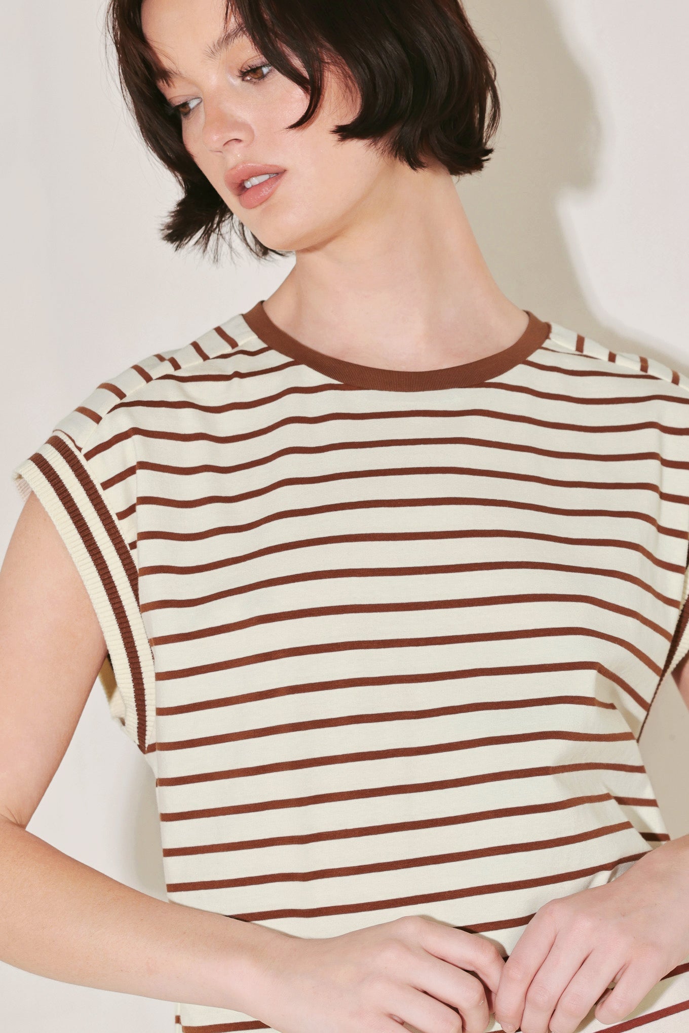 Woman wearing a striped shirt with a plain background