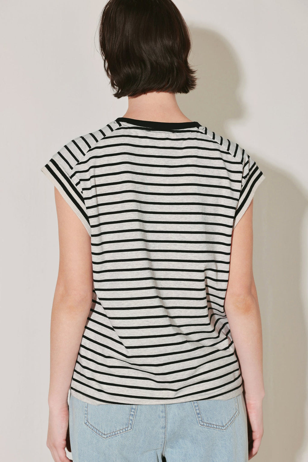 Person wearing a black and white striped shirt against a plain background
