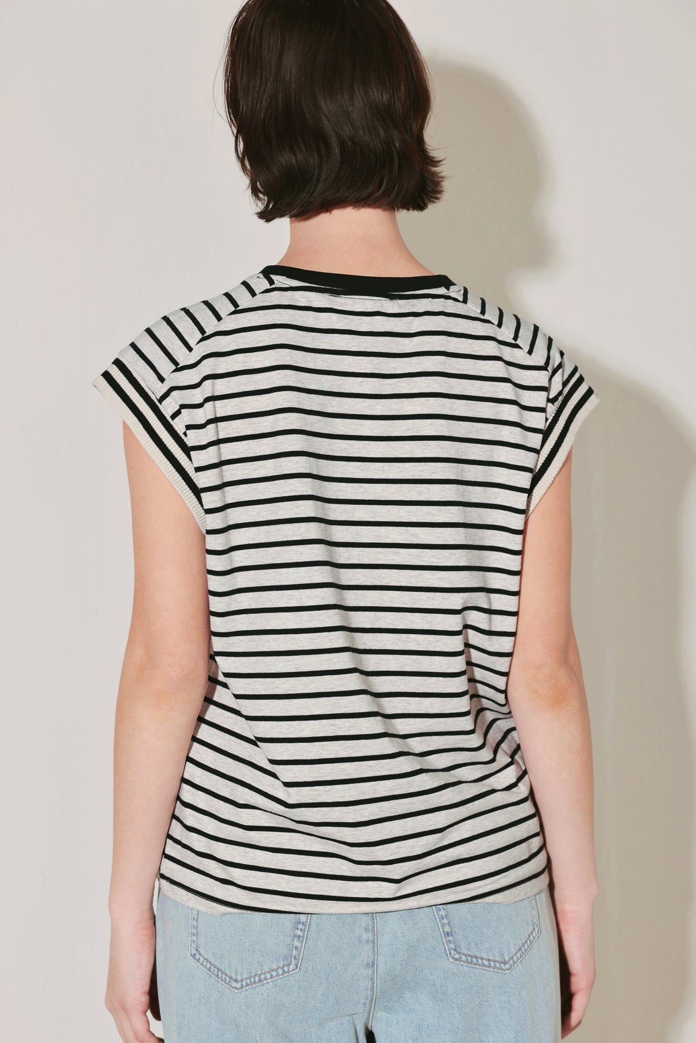 Person wearing a black and white striped shirt against a plain background
