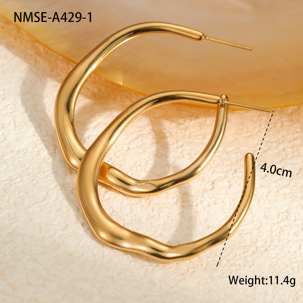 Gold hoop earrings on a textured beige surface with measurement details.