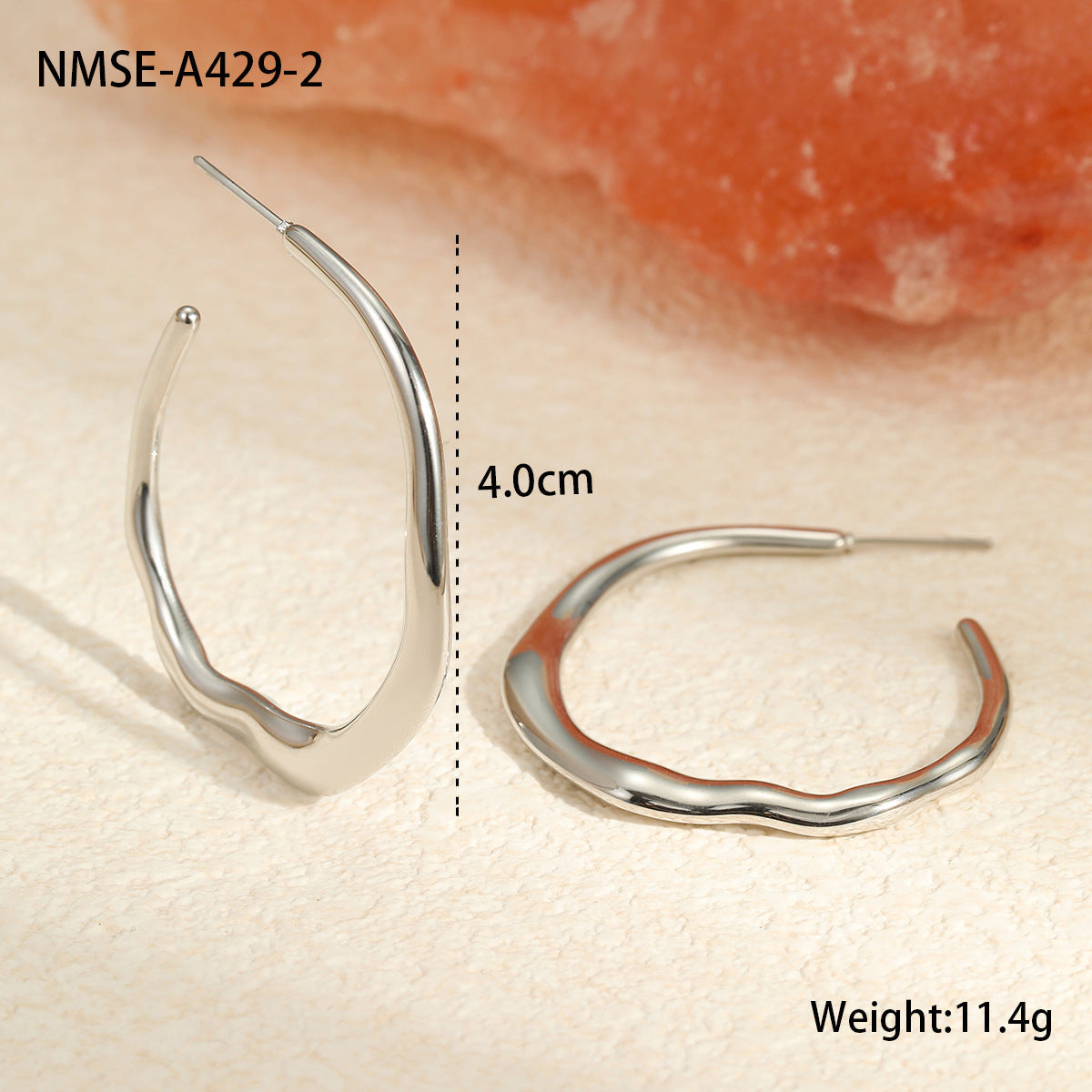 Silver hoop earrings with measurements on a beige background