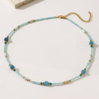 Beaded necklace with blue and gold accents on a white background