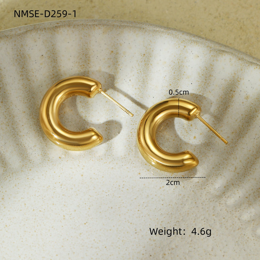 Gold hoop earrings on a textured beige surface with measurements and weight displayed.
