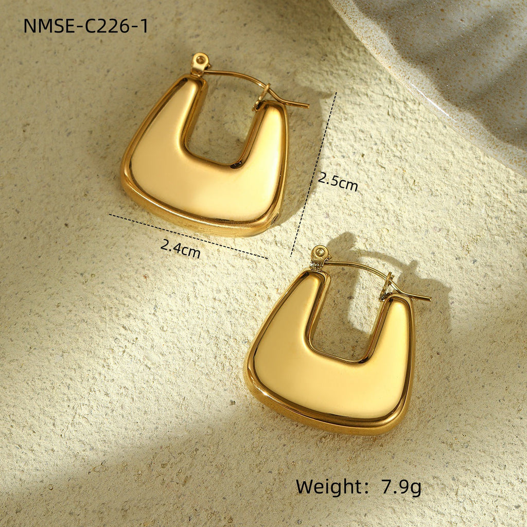 Gold hoop earrings on a textured beige surface with measurements and weight displayed.