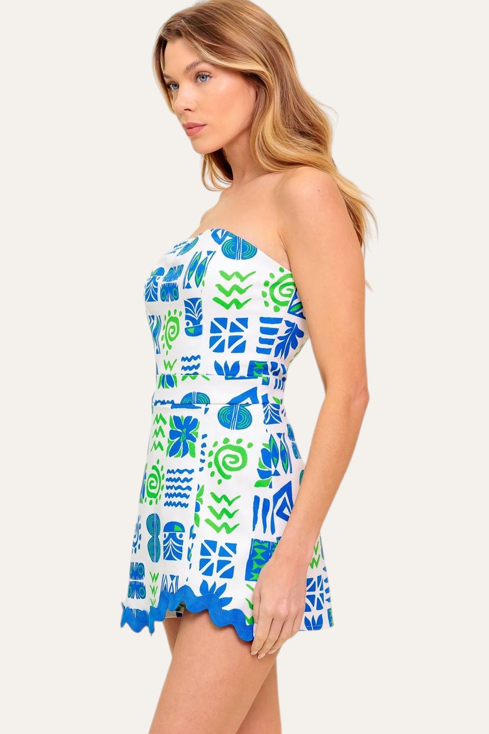 Winged Meadow Co. strapless mini dress with blue and green abstract print, sweetheart neckline, and scalloped hem.