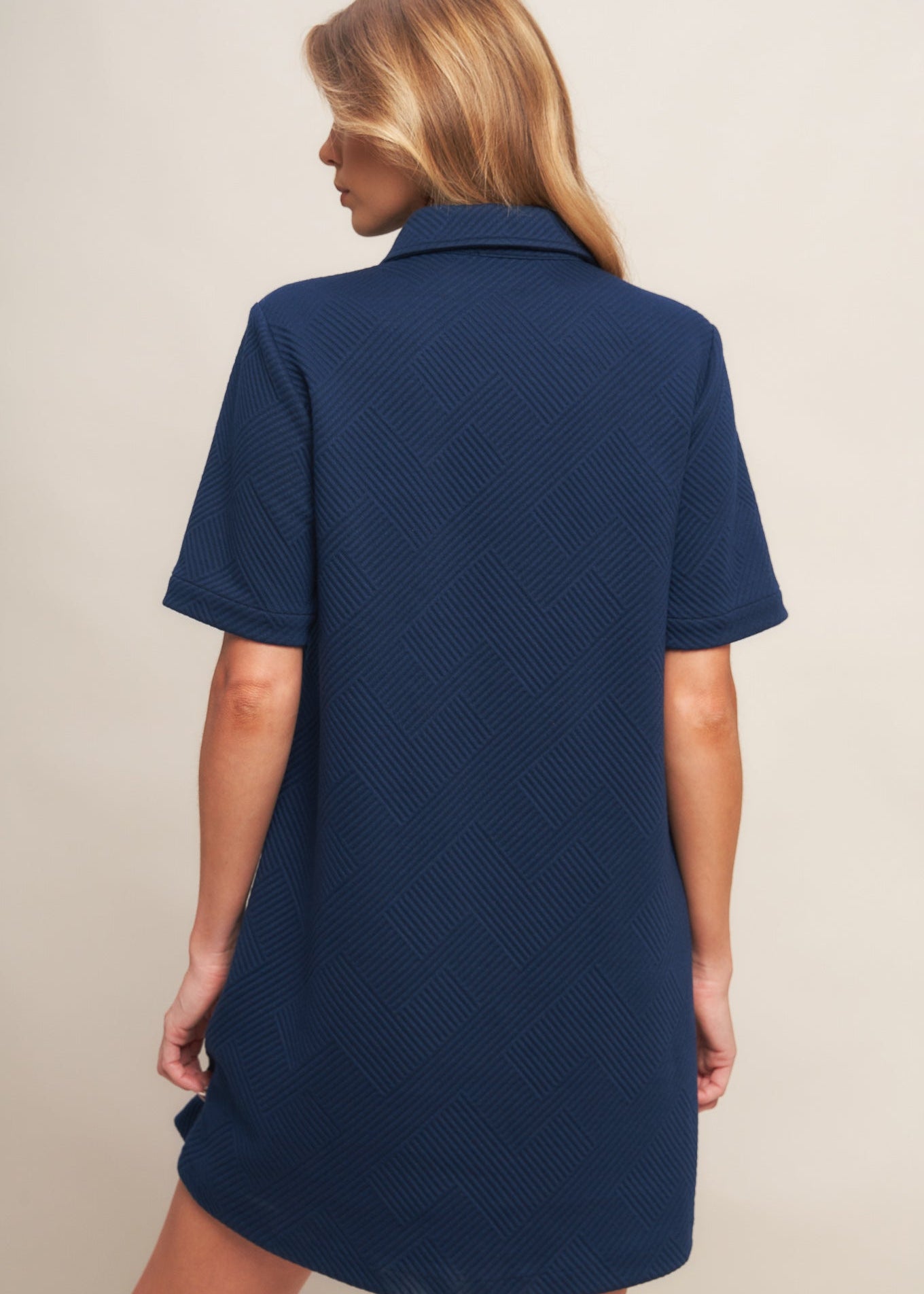 Back view of navy textured knit mini dress with clean minimalist design