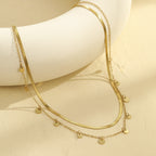 Gold necklace with heart pendants on a white surface