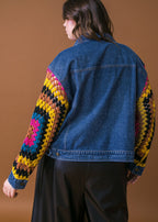 Back view of plus size washed denim jacket with crochet sleeves