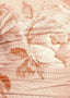 Close-up of a textured fabric with floral patterns in soft pink and peach tones.