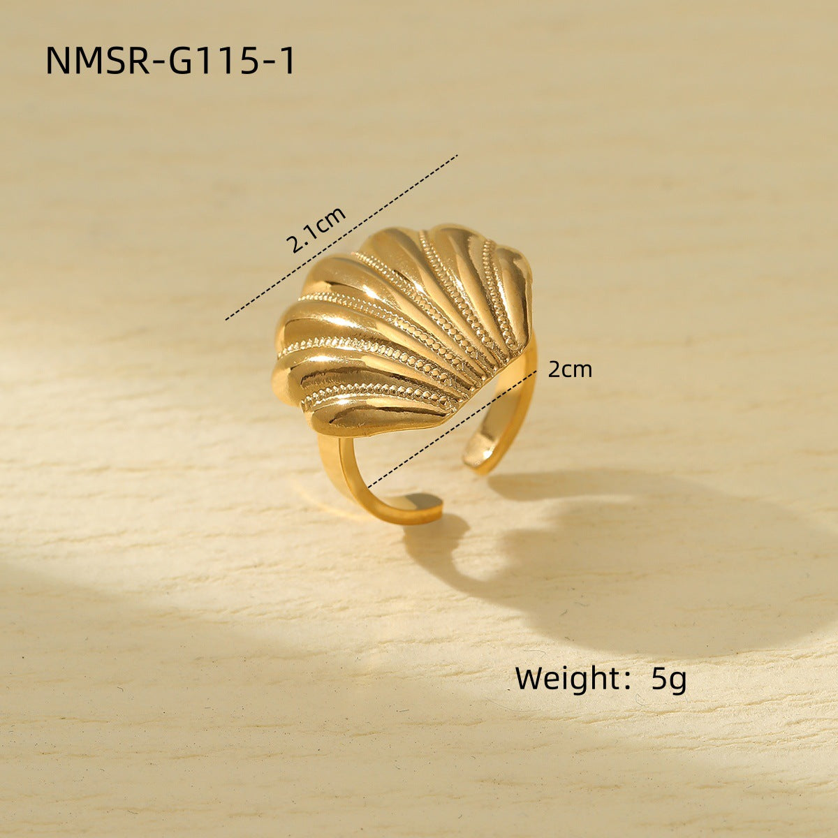Gold shell-shaped ring with measurements and weight on a wooden surface