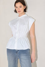 Winged Meadow - White cotton button-down top with corset waist and peplum hem styled with denim