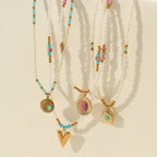 Set of beaded necklaces with gold pendants on a beige background