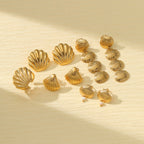 Gold shell earrings collection with stud and drop styles on neutral background