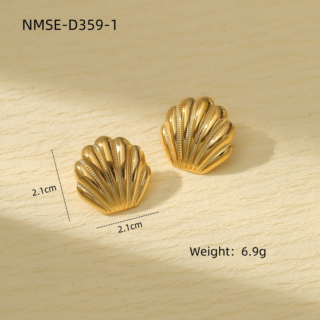 Gold shell-shaped earrings on a wooden surface with measurements and weight displayed.