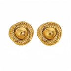 Model wearing spiral gold stud earrings with statement design