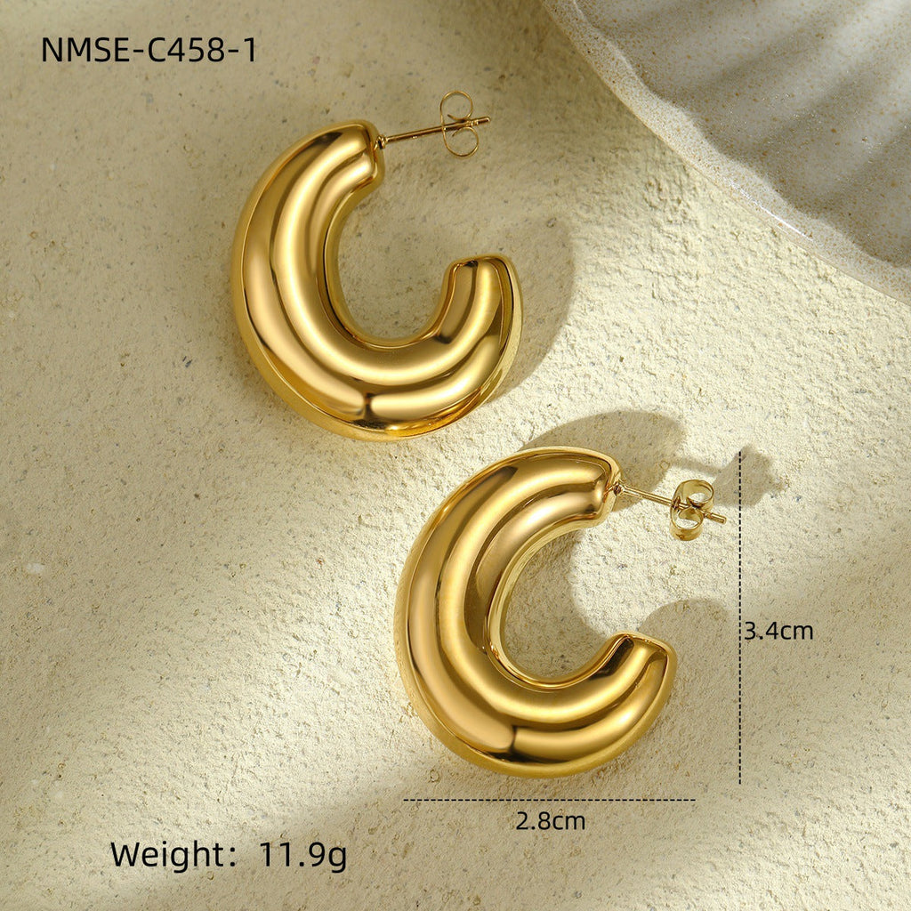 Gold hoop earrings on a textured beige surface with measurements and weight displayed.