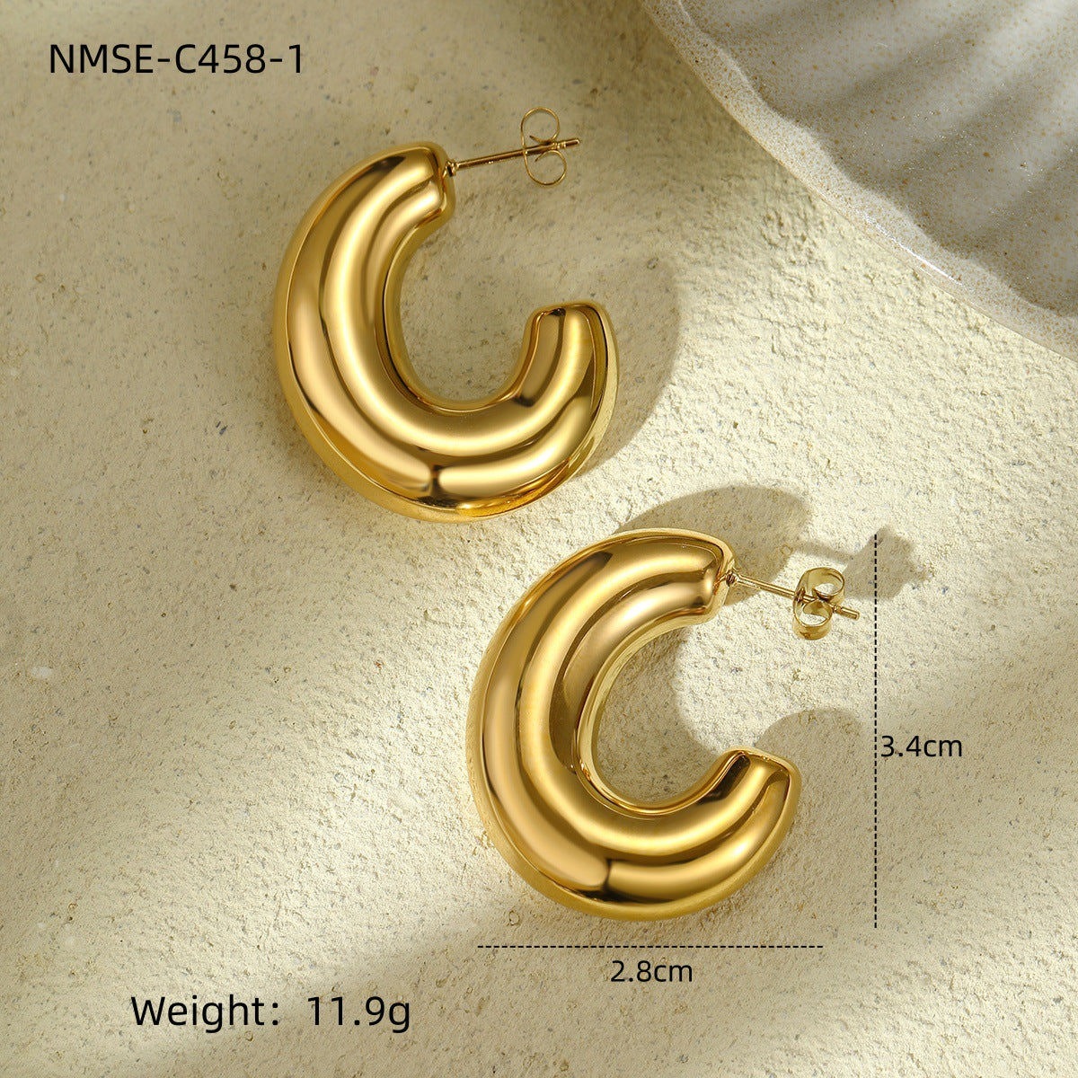 Gold hoop earrings on a textured beige surface with measurements and weight displayed.
