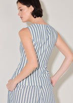 Woman wearing a blue and white striped dress against a plain background