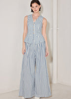 Woman wearing a blue and white striped jumpsuit on a plain background