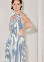 Woman wearing a blue and white striped dress against a plain background