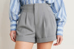 Close up detail of structured woven shorts with front closure and pleats