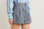 Light indigo tailored woven shorts with structured pleating and cuffed hem