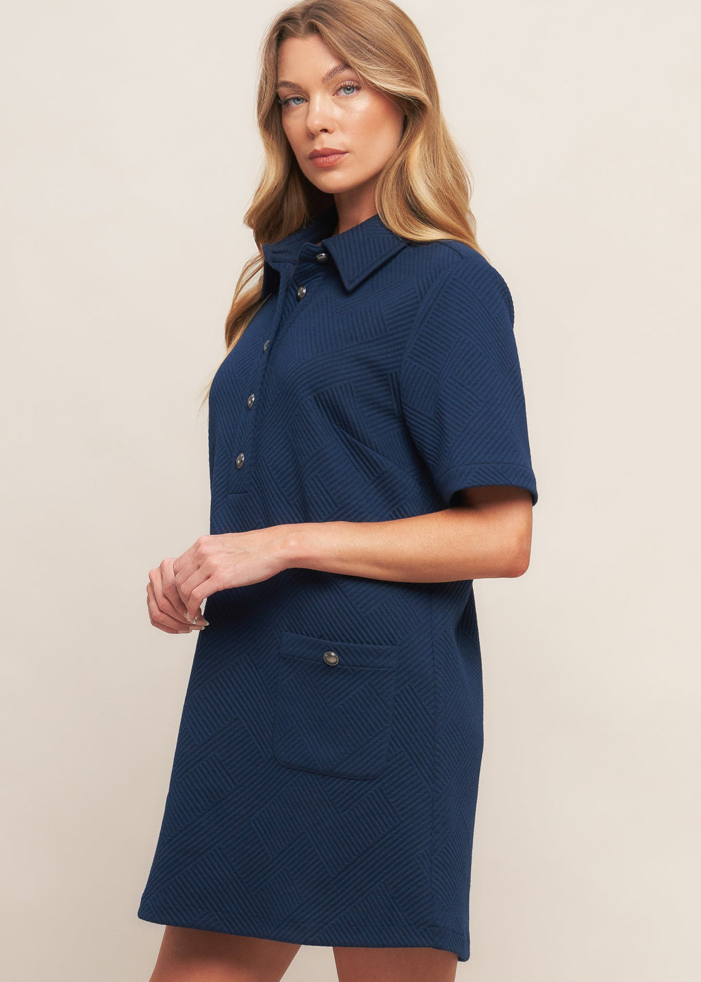 Side view of navy textured knit mini dress with short sleeves and modern silhouette