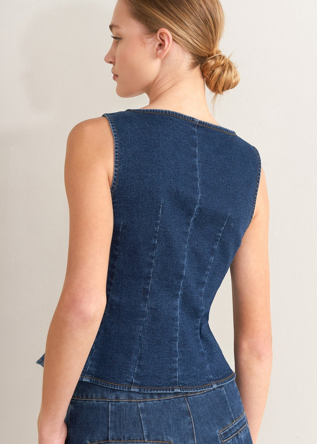 Winged Meadow Co. dark wash denim sleeveless vest with wide neckline and contoured fit. Cotton blend.