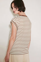 Woman wearing a striped shirt against a plain background